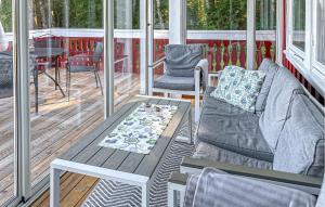 a screened in porch with a couch and a table at Awesome Home In Munkedal With Wifi in Munkedal