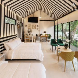 a bedroom with a large bed and a table and chairs at S-Cape at Rim Khwae in Ban Tha Thong Mon