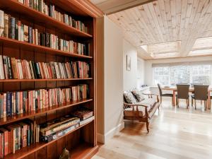 a library with wooden shelves filled with books at Mill View in Aberfeldy
