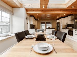 a dining room with a long table and chairs at Mill View in Aberfeldy +17 photos