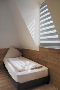 a small bed in a room with a window at Hotel Gasthaus Krone in Cologne