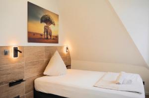 a bedroom with a bed with a picture of an elephant at Hotel Gasthaus Krone in Cologne
