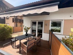 a patio with a table and chairs on a deck at kleines KunzGlück in Waldbronn