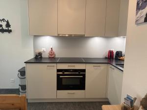 a kitchen with white cabinets and a black counter top at Magic Moments in Brail