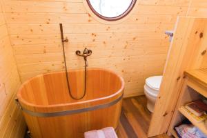 a wooden tub in a bathroom with a toilet at Maringotka Bára in Huslenky