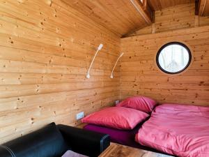 a room with two beds in a wooden cabin at Maringotka Bára in Huslenky