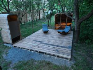 a wooden deck with two chairs and a trailer at Maringotka Bára in Huslenky