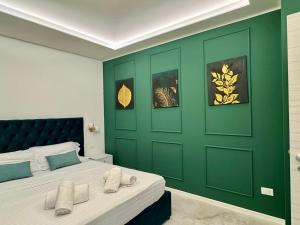 a bedroom with a green wall with a bed at Duomo Next Accomodations in Trento
