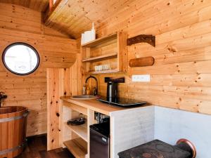 a kitchen in a log cabin with wooden walls at Maringotka Bára in Huslenky