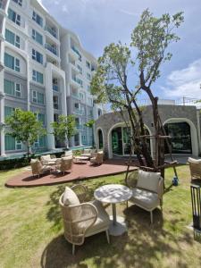 a large apartment building with chairs and a table at Serenity Naiyang Най Янг D02 in Nai Yang Beach