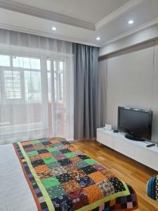 a bedroom with a bed and a flat screen tv at Undraa's cosy small apt in Ulaanbaatar