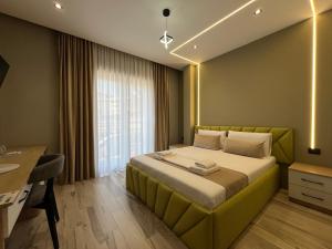 a bedroom with a green bed with a desk and a window at Mont Blanc Hotel in Peshkopi +31 photos