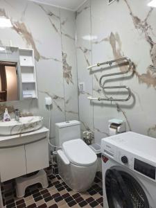 a bathroom with a washer and a washing machine at Undraa's cosy small apt in Ulaanbaatar