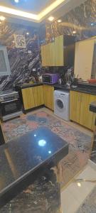 a kitchen with a table and a washing machine at Couple's Cove in Luxor
