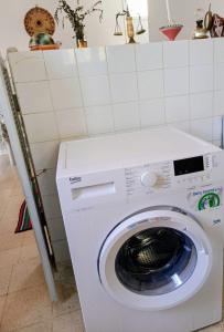 a washing machine in a room with a tiled wall at Dar Essadeg in Tataouine