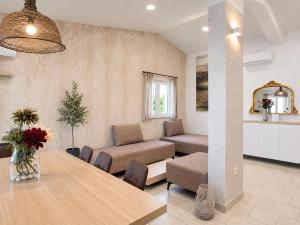 a living room with a table and a couch at OrkulaBliss Apartments in Pašman