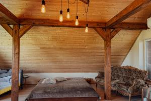 a bedroom with a bed and a wooden ceiling at Vējkalni in Myza Dzirtsiyems