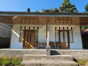 a small white house with a table and chairs at Senaru Garden Homestay in Senaru