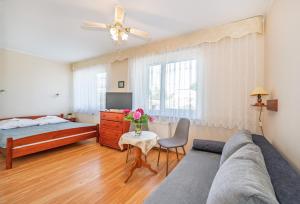 a bedroom with a couch and a bed and a table at Bajka in Dąbki