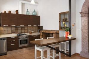 a kitchen with wooden cabinets and a wooden table at Cas Coco – 8-Person Townhouse near Playa de Muro ⭐ in Muro