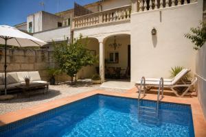 a swimming pool in a courtyard with a house at Cas Coco – 8-Person Townhouse near Playa de Muro ⭐ in Muro