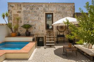 a patio with a swimming pool and an umbrella at Cas Coco – 8-Person Townhouse near Playa de Muro ⭐ in Muro
