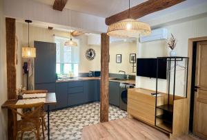 a kitchen with blue cabinets and a table in it at Studio centre historique - Climatisé in Pézenas