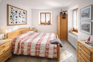 a bedroom with a bed with a red and white blanket at L'Antica Canonica di Casa Bernardi, terrazzo Wi-Fi PetFriendly con Area Cani in Trento