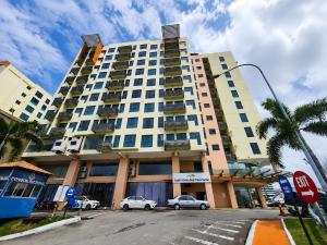 a large building with cars parked in front of it at Cozy Studio at SCSP Suites in Kota Kinabalu