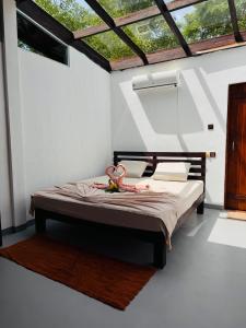 a bedroom with a bed in a room with windows at Glass Roof Southern Edge Cabanas in Tangalle