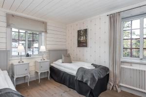 a bedroom with a bed and two windows at Ulkeröds Gård in Hedekas +136 photos