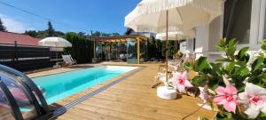 a house with a swimming pool and an umbrella at GoldenApart Apartamenty 2-sypialniowe - Grzany Basen - Kameralny Klimat in Krynica Morska +61 photos