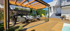 an outdoor deck with chairs and a pergola at GoldenApart Apartamenty 2-sypialniowe - Grzany Basen - Kameralny Klimat in Krynica Morska