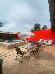a patio with chairs and a table with an umbrella at Chacara Mansao completa 28 pessoas TOMORROWLAND in Itu