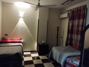 a room with two beds and a light on the wall at Couple's Cove in Luxor +10 photos