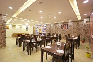 a restaurant with wooden tables and chairs and a brick wall at Hotel Ronit Royal - Delhi Airport in New Delhi