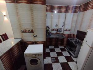 a kitchen with a washer and a checkered floor at Couple's Cove in Luxor