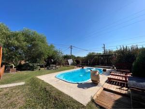 a swimming pool in a yard with two benches at El rancho in Parana