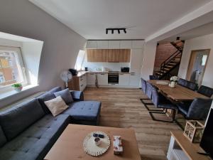 a living room with a blue couch and a table at Zelená in Františkovy Lázně