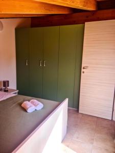 a bedroom with green cabinets and a bed with two towels at La Casa del Cedro - Riposto in Riposto