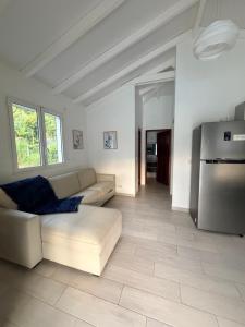 a living room with a couch and a refrigerator at Les Trésors de Laurëlia in Gourbeyre