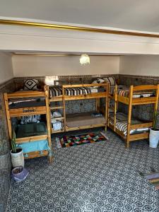 a room with three bunk beds in it at Ifni Flow Seafront surfhouse in Sidi Ifni