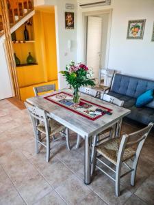 a dining room table with a vase of flowers on it at La Casa del Cedro - Riposto in Riposto +29 photos