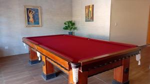 a red pool table in a room with paintings at Chacara Mansao completa 28 pessoas TOMORROWLAND in Itu +13 photos