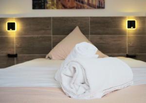 a pile of towels sitting on top of a bed at Hotel Gasthaus Krone in Cologne