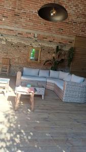 a couch and a table and a brick wall at La CHAMBRE BLEUE in Lézat-sur-Lèze +3 photos