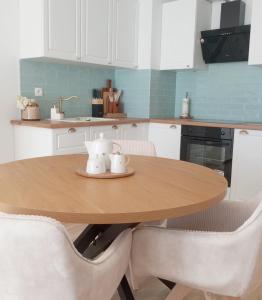 a kitchen with a wooden table and white cabinets at Kawalerka pod lasem in Poddębice +1 photo