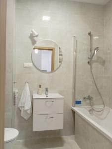a bathroom with a shower and a sink and a mirror at Kawalerka pod lasem in Poddębice