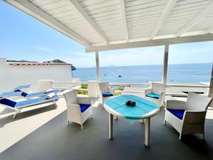 a patio with chairs and a table and the ocean at La Dimora sul Mare in Sant'Angelo D'Ischia