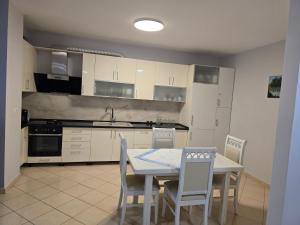 a kitchen with a table and chairs in it at Puzzle Apart Rooms in Tirana